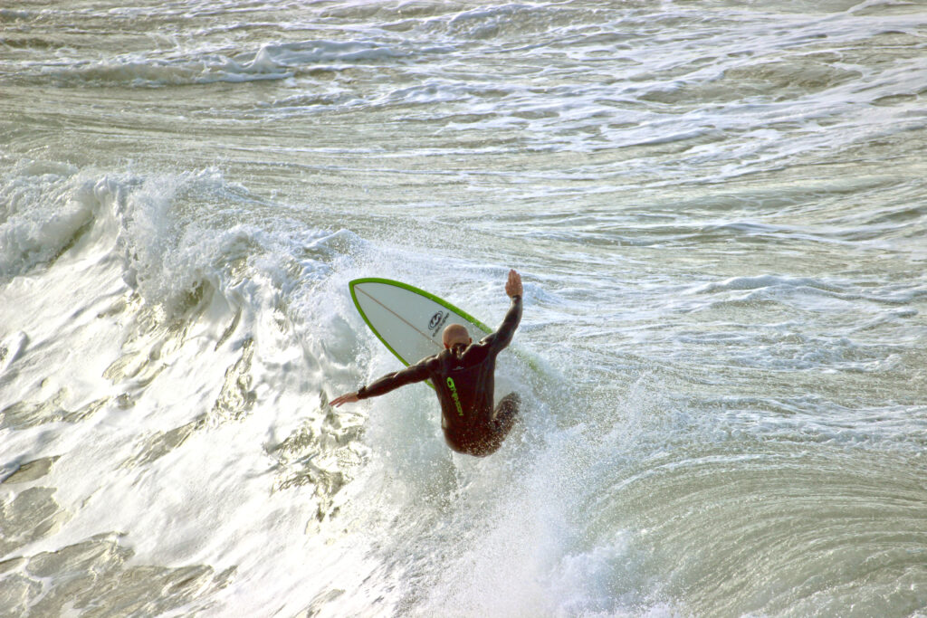 Dom riding a wave on his surfboard.