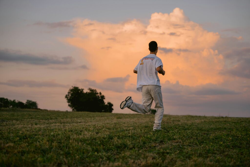 Man running on grass with a view of the sky