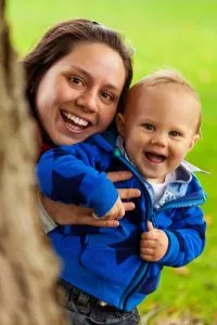 Photo of Jane holding her baby both smiling.