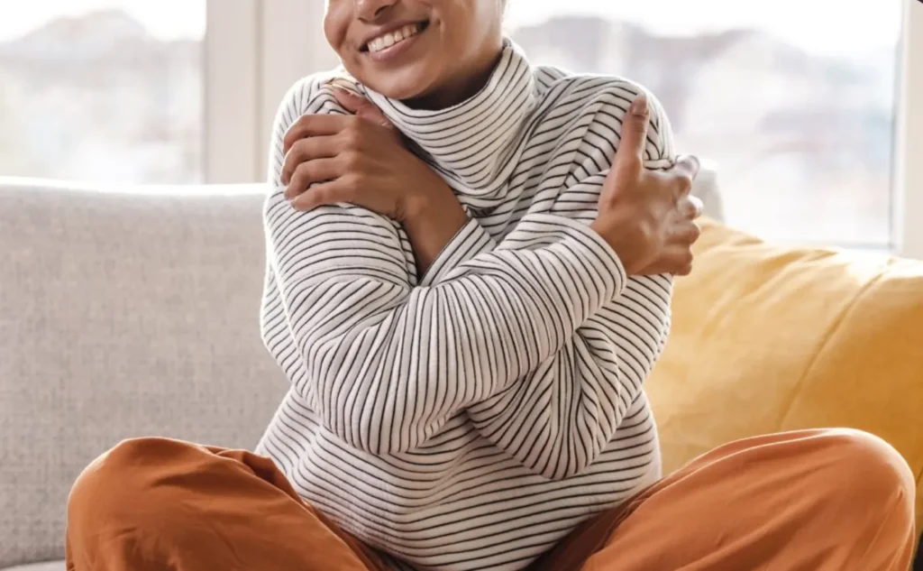 person smiling holding their arms