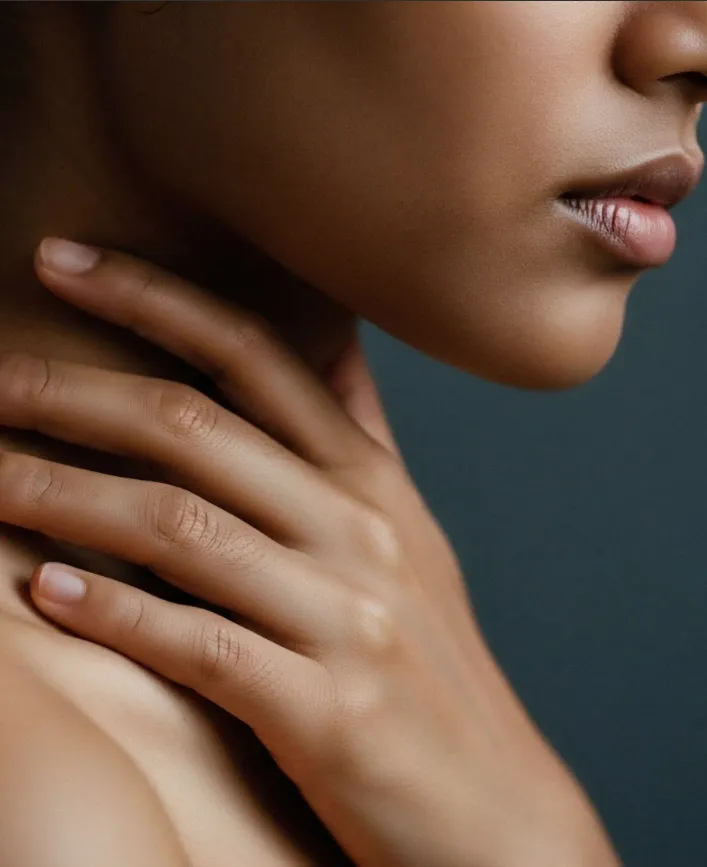 woman's face and her hand on her neck